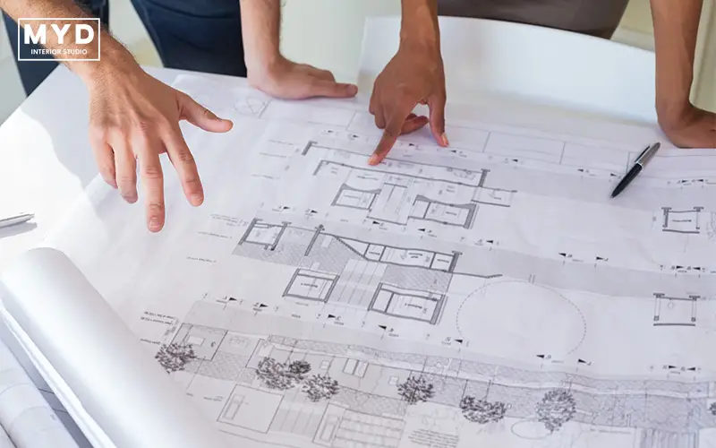 Architects discussing blueprints for A&A renovation project.