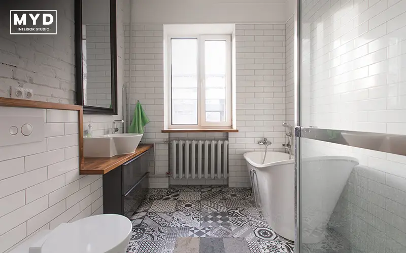 Renovated bathroom with subway tiles and patterned floor.